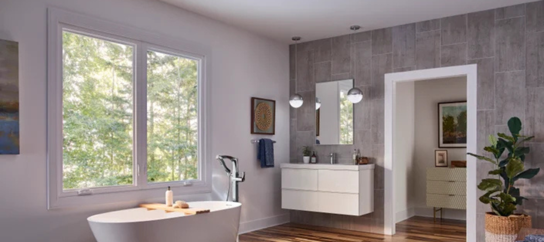 Bright modern bathroom featuring a freestanding tub and a large window with a nature view