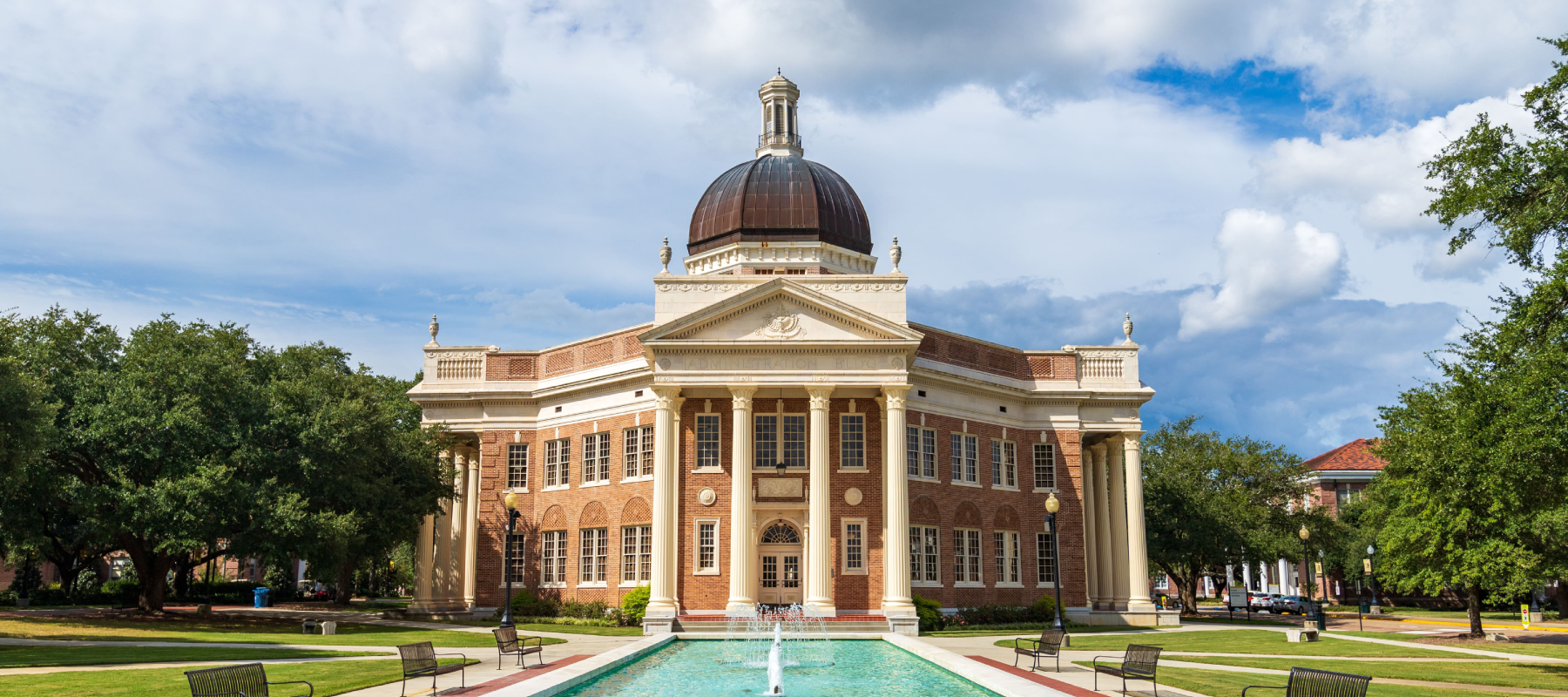 Classical-style brick building with a large dome and columned entrance on a university campus